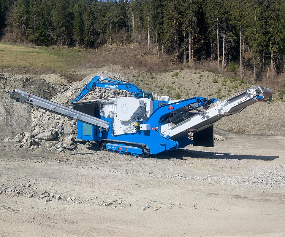 Gipo B0960 Giga Concasseur à mâchoires mobile au pied de la paroi ; convoyeur latéral évacuant les granulats.