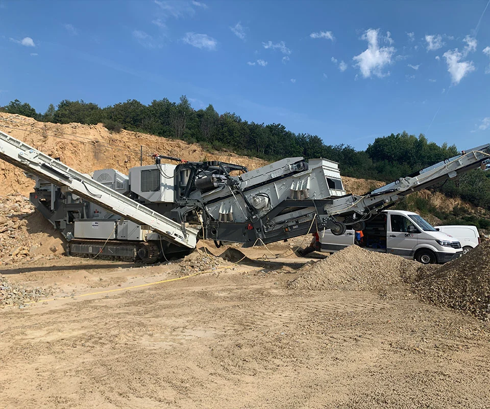 Gipo B1170 Mobile jaw crushing plant working against the quarry face; side conveyor discharging aggregate.
