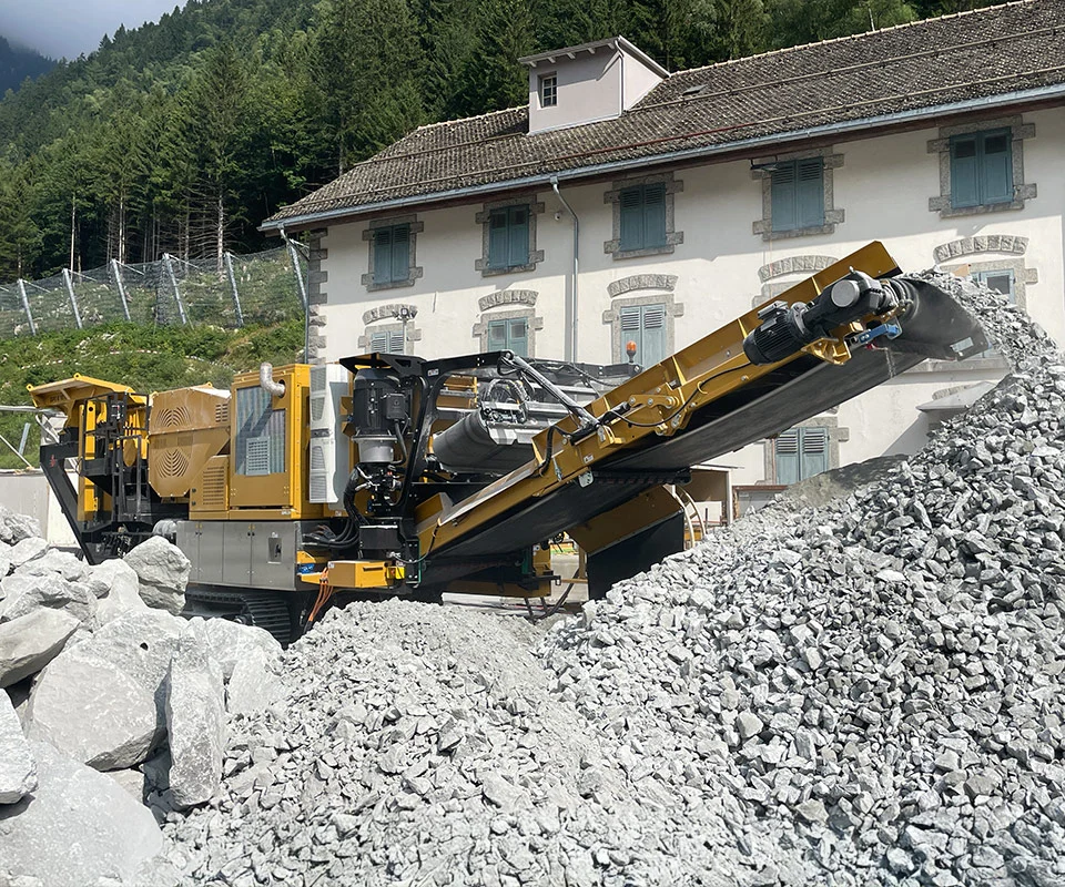 Gipo B1270 Mobile jaw crushing plant working against the quarry face; side conveyor discharging aggregate.