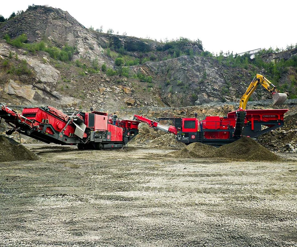 Gipo B1290 Mobile jaw crushing plant in a quarry, excavator feeding the hopper; conveyors stockpiling crushed rock