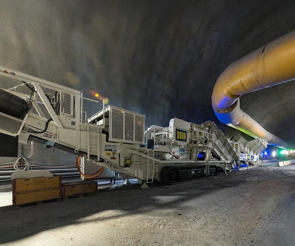 Gipo B1490 Mobile jaw crushing plant on tracks, processing blasted rock; discharge conveyors forming piles.