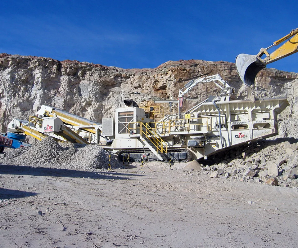Gipo P170 Concasseur à percussion mobile GIPO traitant la roche sur site; crible et convoyeurs intégrés, tas de granulats.