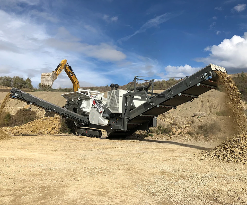 Gipo P170 Concasseur à percussion mobile GIPO traitant la roche sur site; crible et convoyeurs intégrés, tas de granulats.
