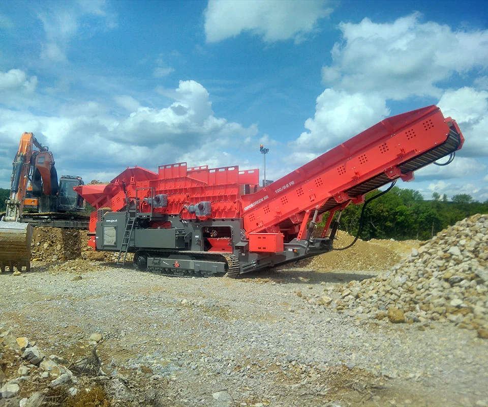 Gipo RR 100 Mobile roller grizzly plant being fed by excavator; stockpile forming under discharge conveyor.