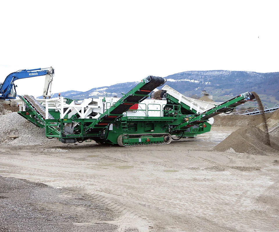 Gipo S 2160 Cribleur mobile avec grande trémie d’alimentation et convoyeur principal sur châssis chenillé.