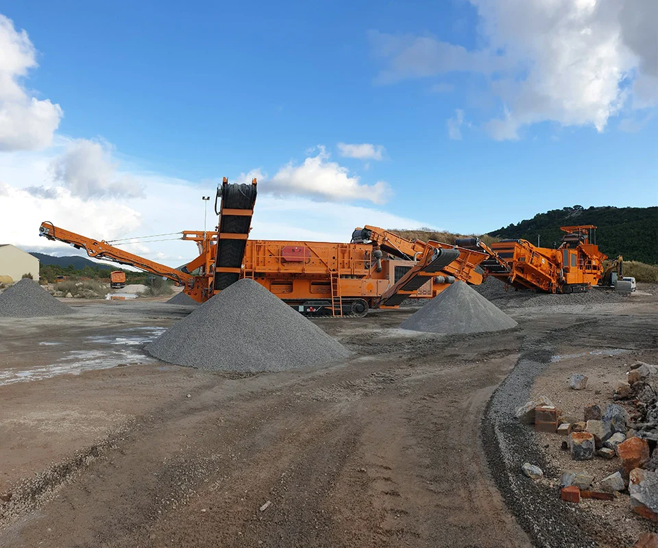 Gipo S 2160 Cribleur mobile (2 étages) sur châssis chenillé, avec trémie d’alimentation et convoyeurs, configuration compacte.