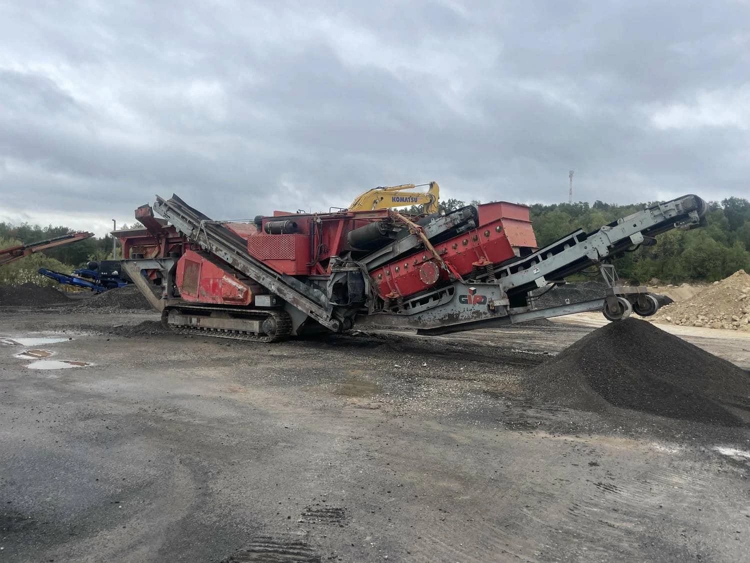 Mobile GIPO Prallbrechanlage im Einsatz mit Austragsband und Haldenmaterial
