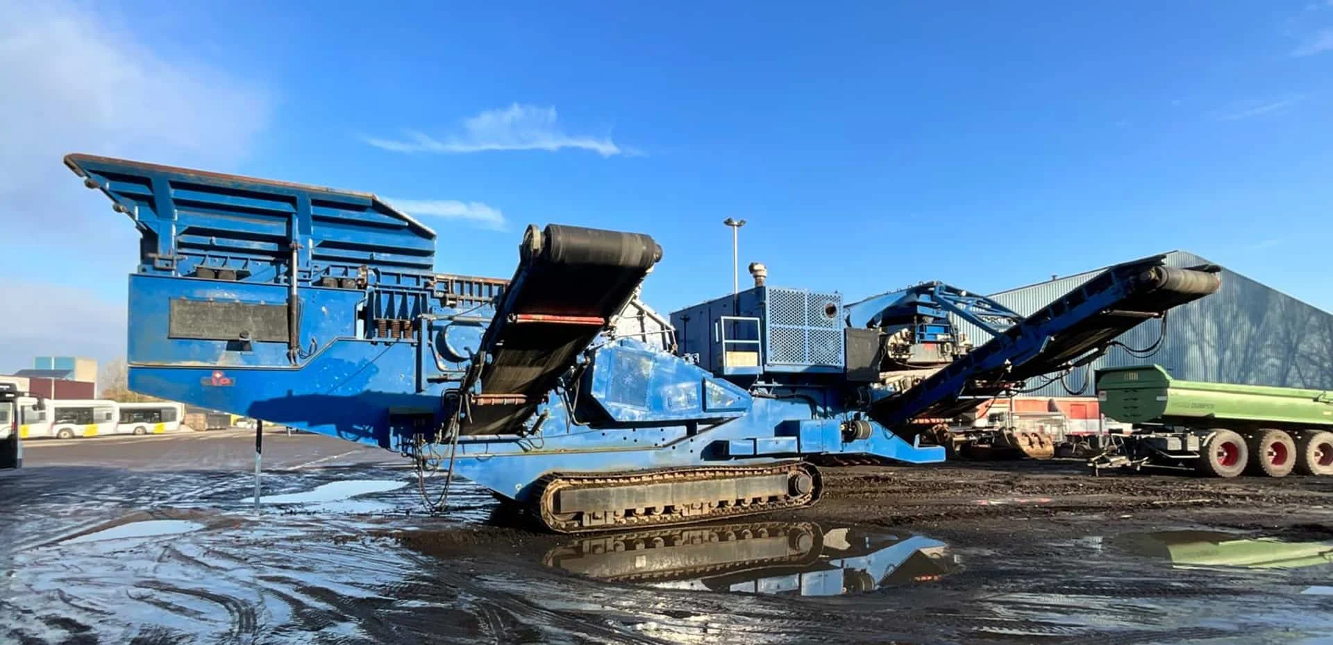 Seitenansicht der mobilen Prallbrechanlage mit Austragsbändern